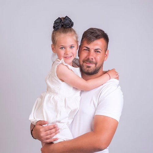 Un padre sujeta en brazos a su hija